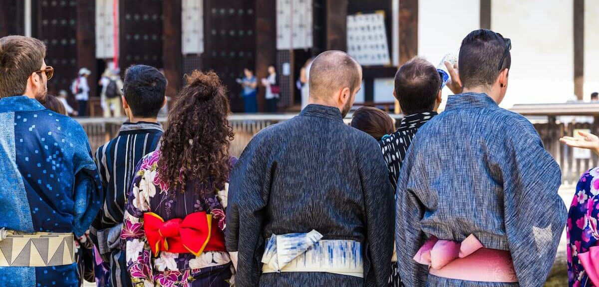 浴衣を着て観光している人たちの後ろ姿
